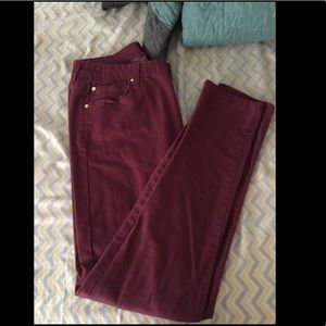 Maroon colored skinny jeans.
